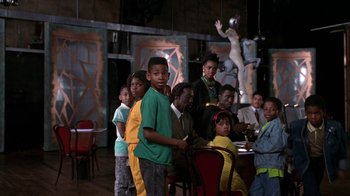 Movie still from “New Jack City” (1991), directed by Mario Van Peebles – A group of children standing around a table; Medium shot, High angle