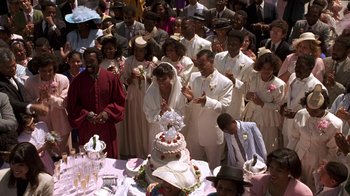 Movie still from “New Jack City” (1991), directed by Mario Van Peebles – A group of people standing in front of a wedding cake; Wide shot, High angle