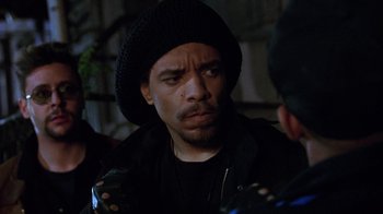 Movie still from “New Jack City” (1991), directed by Mario Van Peebles – A person wearing a hat; Close Up shot, Over the shoulder angle