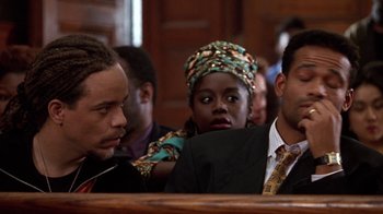 Movie still from “New Jack City” (1991), directed by Mario Van Peebles – A group of people sitting in a court room; Close Up shot, Low angle