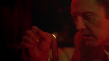 Movie still from “New Rose Hotel” (1998), directed by Abel Ferrara – A man holding a piece of food in his hand; Close Up shot, Over the shoulder angle