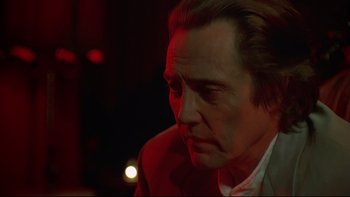 Movie still from “New Rose Hotel” (1998), directed by Abel Ferrara – A person wearing a suit and tie; Close Up shot, Low angle