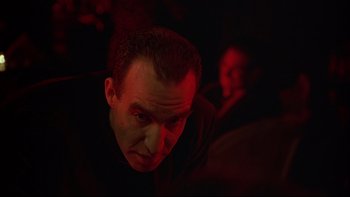 Movie still from “New Rose Hotel” (1998), directed by Abel Ferrara – A person in a dark room; Close Up shot, Low angle