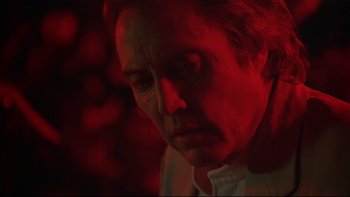 Movie still from “New Rose Hotel” (1998), directed by Abel Ferrara – A man in a white shirt is looking down at his face; Close Up shot, Low angle