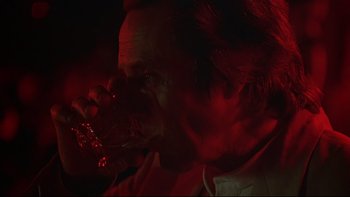 Movie still from “New Rose Hotel” (1998), directed by Abel Ferrara – A man drinking a glass of red wine; Close Up shot, Low angle