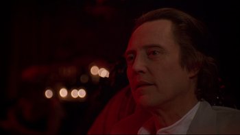 Movie still from “New Rose Hotel” (1998), directed by Abel Ferrara – A person wearing a white shirt; Close Up shot, Over the shoulder angle