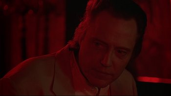 Movie still from “New Rose Hotel” (1998), directed by Abel Ferrara – A person wearing a suit and tie; Close Up shot, Low angle