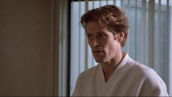 Movie still from “New Rose Hotel” (1998), directed by Abel Ferrara – A person wearing a robe near a window; Close Up shot, Over the shoulder angle