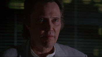 Movie still from “New Rose Hotel” (1998), directed by Abel Ferrara – A person wearing a white shirt; Close Up shot, Low angle