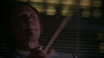 Movie still from “New Rose Hotel” (1998), directed by Abel Ferrara – A person holding a drum stick; Close Up shot, Low angle