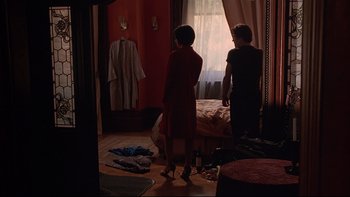 Movie still from “New Rose Hotel” (1998), directed by Abel Ferrara – Two women standing in front of a window in a room; Wide shot, High angle