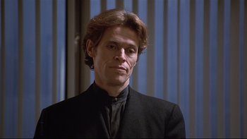 Movie still from “New Rose Hotel” (1998), directed by Abel Ferrara – A person wearing a suit and tie; Close Up shot, Low angle