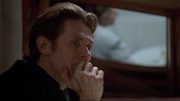 Movie still from “New Rose Hotel” (1998), directed by Abel Ferrara – A person with his hand to his face; Close Up shot, Over the shoulder angle