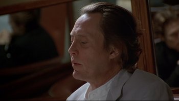 Movie still from “New Rose Hotel” (1998), directed by Abel Ferrara – A person wearing a white shirt; Close Up shot, Low angle