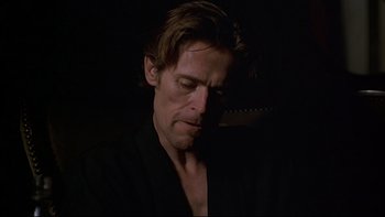Movie still from “New Rose Hotel” (1998), directed by Abel Ferrara – A person wearing a black shirt; Close Up shot, Low angle