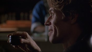 Movie still from “New Rose Hotel” (1998), directed by Abel Ferrara – A person holding a cell phone; Close Up shot, Low angle