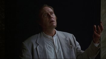 Movie still from “New Rose Hotel” (1998), directed by Abel Ferrara – A man in a white jacket looking up at the sky; Close Up shot, Low angle
