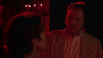 Movie still from “New Rose Hotel” (1998), directed by Abel Ferrara – A man is looking at a woman in the mirror; Close Up shot, Over the shoulder angle