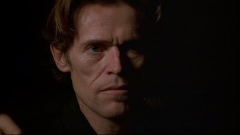 Movie still from “New Rose Hotel” (1998), directed by Abel Ferrara – A man's face in the dark; Close Up shot, Low angle
