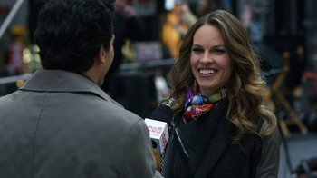 Movie still from “New Year's Eve” (2011), directed by Garry Marshall – A woman smiles while being interviewed by a man; Close Up shot, Over the shoulder angle