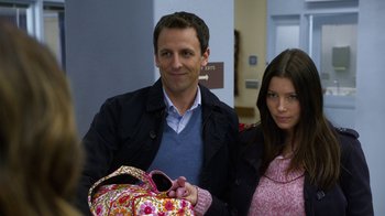 Movie still from “New Year's Eve” (2011), directed by Garry Marshall – A man and a woman standing next to each other holding a baby; Medium shot, Over the shoulder angle