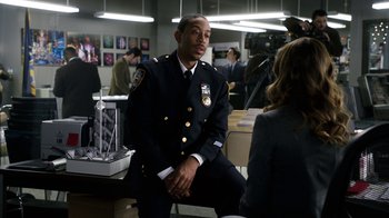 Movie still from “New Year's Eve” (2011), directed by Garry Marshall – A police officer sitting in front of a camera; Medium shot, Over the shoulder angle