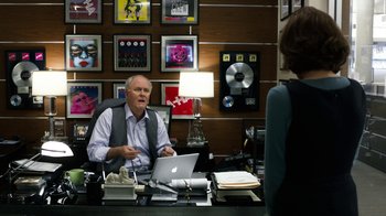 Movie still from “New Year's Eve” (2011), directed by Garry Marshall – A man sitting at a desk in front of a woman; Medium shot, Over the shoulder angle
