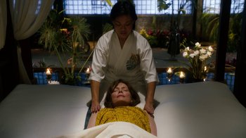 Movie still from “New Year's Eve” (2011), directed by Garry Marshall – A woman getting a reiki treatment on her face; Medium shot, High angle
