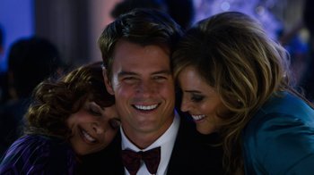 Movie still from “New Year's Eve” (2011), directed by Garry Marshall – A man and two women posing for a picture; Close Up shot, Over the shoulder angle