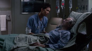 Movie still from “New Year's Eve” (2011), directed by Garry Marshall – An older man in a hospital bed with a nurse; Medium shot, High angle