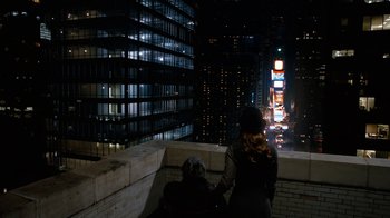 Movie still from “New Year's Eve” (2011), directed by Garry Marshall – Two people sitting on a ledge looking out at a city at night; Wide shot, High angle