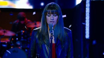 Movie still from “New Year's Eve” (2011), directed by Garry Marshall – A woman with long black hair is holding a microphone; Close Up shot, Low angle