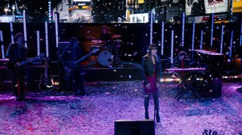 Movie still from “New Year's Eve” (2011), directed by Garry Marshall – A woman singing in front of an audience in front of a crowd; Extreme Wide shot, High angle