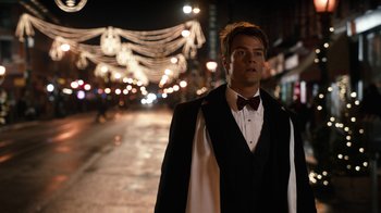 Movie still from “New Year's Eve” (2011), directed by Garry Marshall – A man in a tuxedo standing on the side of the street; Medium shot, Over the shoulder angle