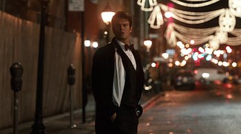 Movie still from “New Year's Eve” (2011), directed by Garry Marshall – A man in a tuxedo standing on the side of the street; Medium shot, Low angle