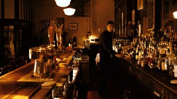 Movie still from “New York, I Love You” (2008), directed by Wen Jiang – A man standing at the bar of a restaurant; Wide shot, High angle