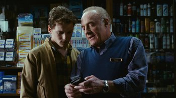 Movie still from “New York, I Love You” (2008), directed by Wen Jiang – An older man and a young boy looking at a cell phone; Medium shot, Low angle