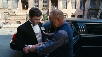 Movie still from “New York, I Love You” (2008), directed by Wen Jiang – An older man helping a young man put on a boutonniere; Medium shot, Over the shoulder angle