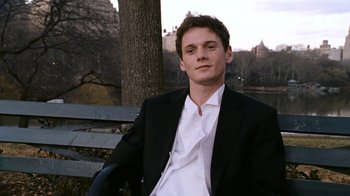 Movie still from “New York, I Love You” (2008), directed by Wen Jiang – A man in a suit sitting on a park bench; Medium shot, High angle
