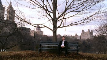 Movie still from “New York, I Love You” (2008), directed by Wen Jiang – A man sitting on a park bench in front of a tree; Extreme Wide shot, Low angle