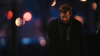 Movie still from “New York, I Love You” (2008), directed by Wen Jiang – A man wearing a black suit and a black tie; Close Up shot, Over the shoulder angle