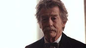 Movie still from “New York, I Love You” (2008), directed by Wen Jiang – An old man with a beard and mustache wearing a suit and bow tie; Close Up shot, Low angle