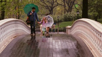 Movie still from “New York, I Love You” (2008), directed by Wen Jiang – A man and a woman walking across a bridge holding umbrellas; Wide shot, High angle