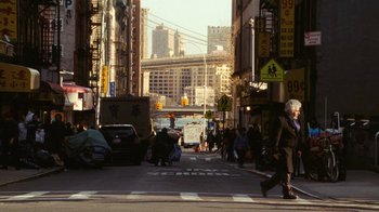 Movie still from “New York, I Love You” (2008), directed by Wen Jiang – A busy city street with cars and people walking on the sidewalk; Wide shot, Over the shoulder angle