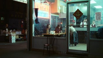 Movie still from “New York, I Love You” (2008), directed by Wen Jiang – Two people sitting at a table in front of a store window; Wide shot, High angle