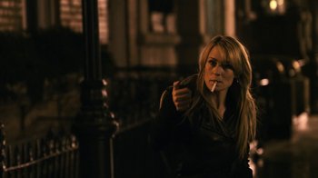 Movie still from “New York, I Love You” (2008), directed by Wen Jiang – A woman smoking a cigarette while sitting on a chair; Medium shot, Over the shoulder angle