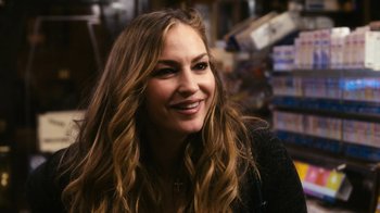 Movie still from “New York, I Love You” (2008), directed by Wen Jiang – A woman with long brown hair smiling for the camera; Close Up shot, Over the shoulder angle