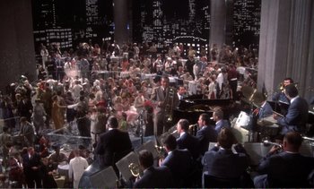 Movie still from “New York, New York” (1977), directed by Martin Scorsese – A large group of people sitting in a large room; Extreme Wide shot, High angle