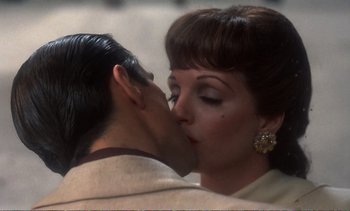 Movie still from “New York, New York” (1977), directed by Martin Scorsese – A man and a woman kissing each other in front of a wall; Close Up shot, Over the shoulder angle