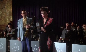 Movie still from “New York, New York” (1977), directed by Martin Scorsese – A man and a woman are singing at a concert; Medium shot, Over the shoulder angle